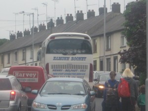 Traffic Chaos with vechicles mounting the pavements and Childrend an parents having to dodge out of the way